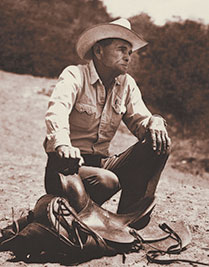 photo of Arnold R. Rojas with hand on saddle horn
